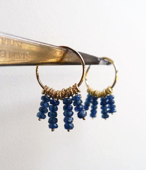 dangle blue and gold unique hoops. 14 karat gold hoop earrings with 4 strings of blue sapphire gemstone beads and braided tiny loop elements. recycled gold fair trade sapphires. oriental boho style handmade gold earrings. evil eye protection color.