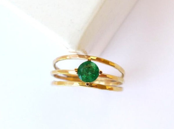 thin hammered gold wires wrapped welded together set with solitaire deep green Emerald conflict free.