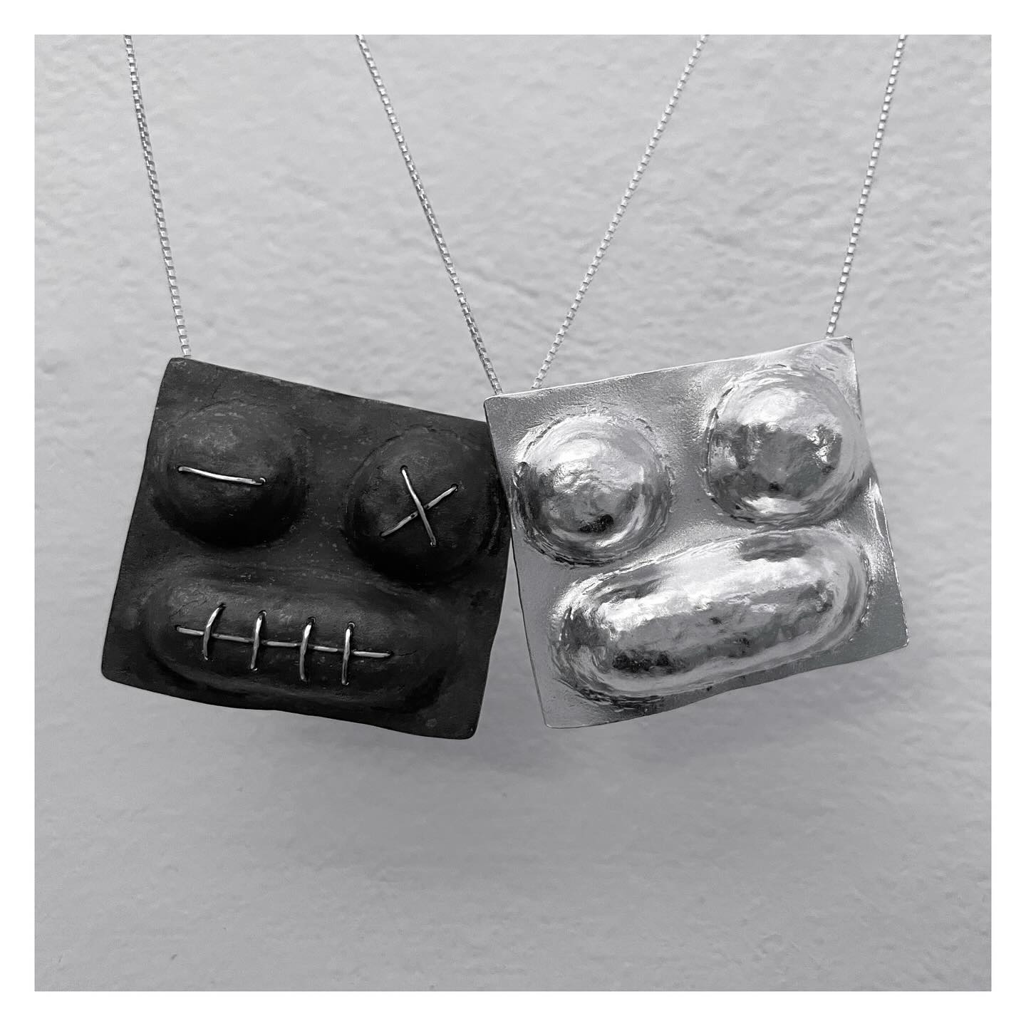 faces pendants puffed handmade necklaces organic tribal stylish runway shiny silver and black dark sewed faces mix match yin yang ART project noa sharon