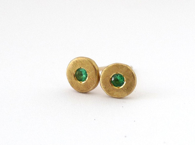 handmade round asymmetric flat solid gold button earrings set with amazing green emerald in the middle